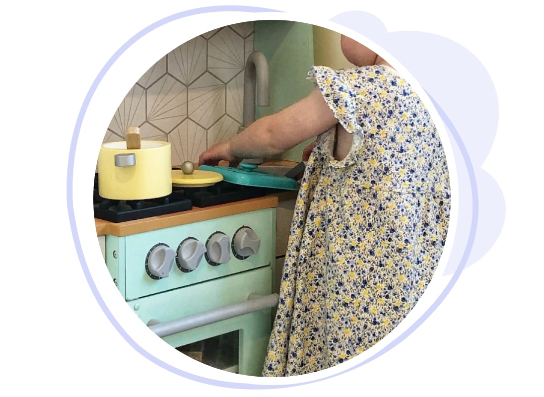 Child playing in toy kitchen